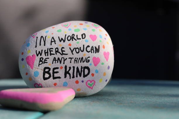 A rock with a written message that reads, "In a world where you can be anything BE KIND"